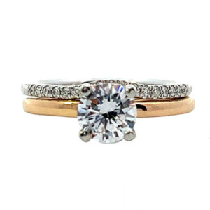 Yellow gold solitaire engagement ring with .06ct tw of brilliant cut diamond melee in the hidden halo and a white gold matching diamond wedding band set with .12ct tw of brilliant cut diamond melee 