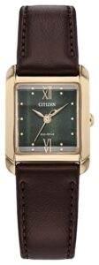 Gold tone stainless steel with green dial and leather strap.